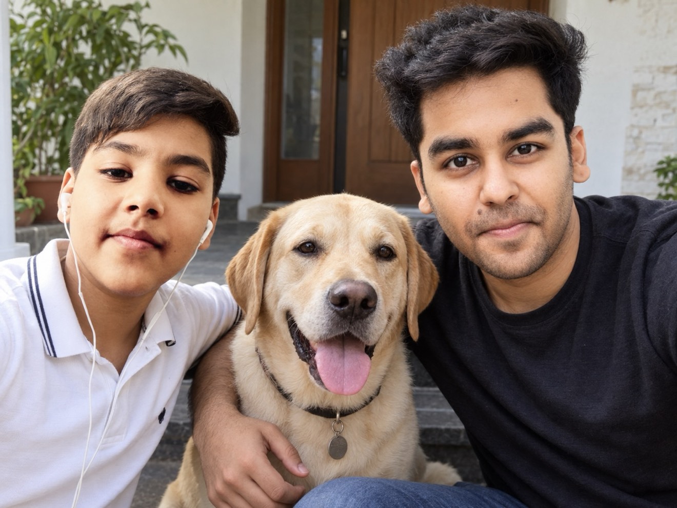 Rish and Laksh sitting on the front steps of the house with Pepsi, a yellow Labrador, between them